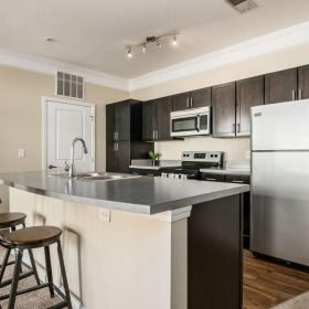 a kitchen with a bar stool and a refrigerator